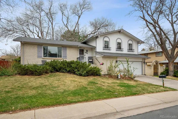 a front view of a house with a yard and trees
