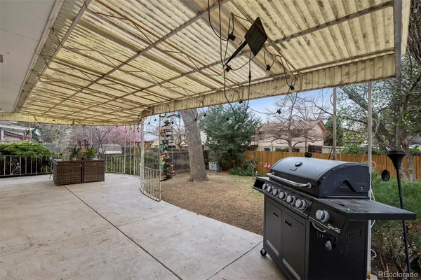 a view of a patio with a table and chairs under an umbrella