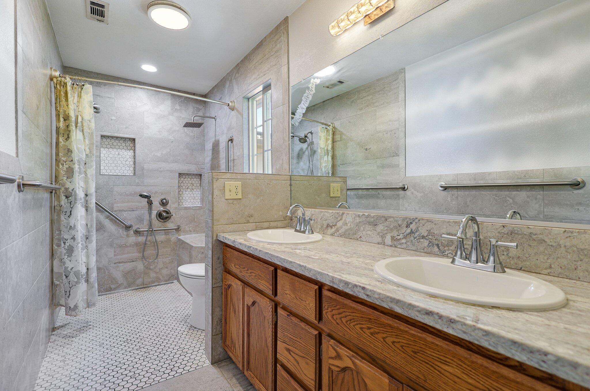 20727 Old Alturas Road Redding, CA 96003 - Photo 17 of 32 a bathroom with a granite countertop sink a toilet a mirror and shower