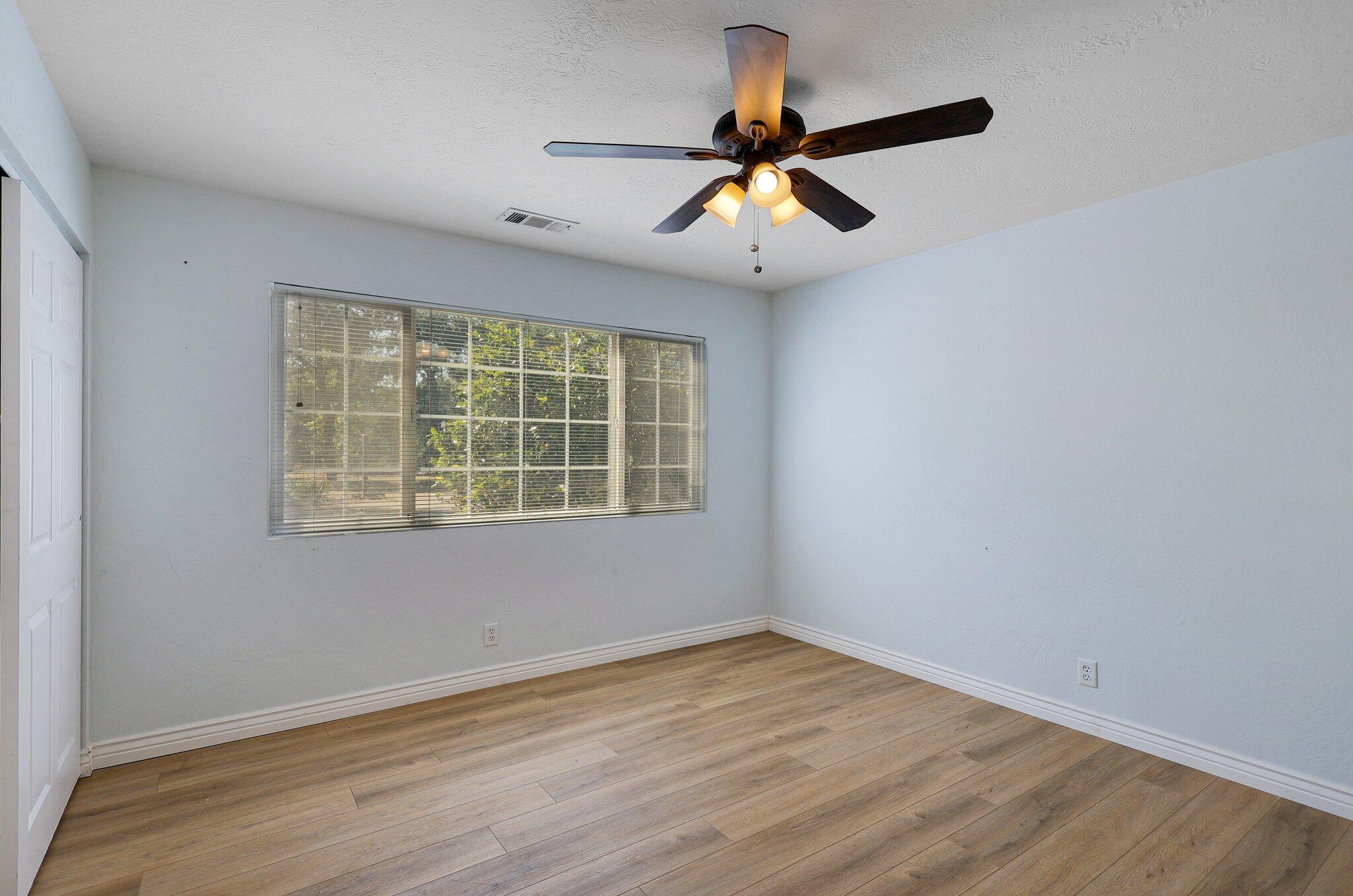 20727 Old Alturas Road Redding, CA 96003 - Photo 20 of 32 a view of an empty room with wooden floor and a window