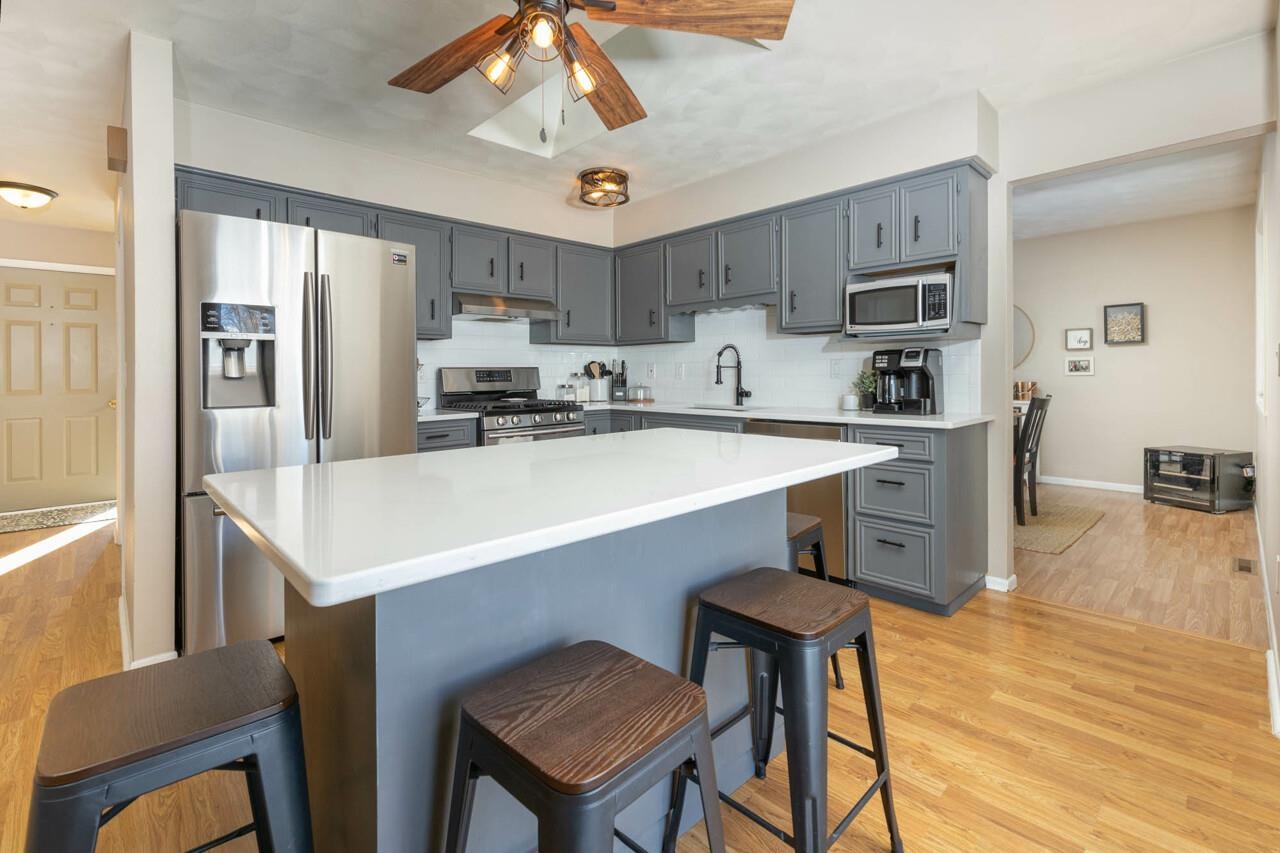 4126 Gloucester Road Roscoe, IL 61073 - Photo 11 of 28 a kitchen with stainless steel appliances a sink a stove a refrigerator cabinets and a dining table