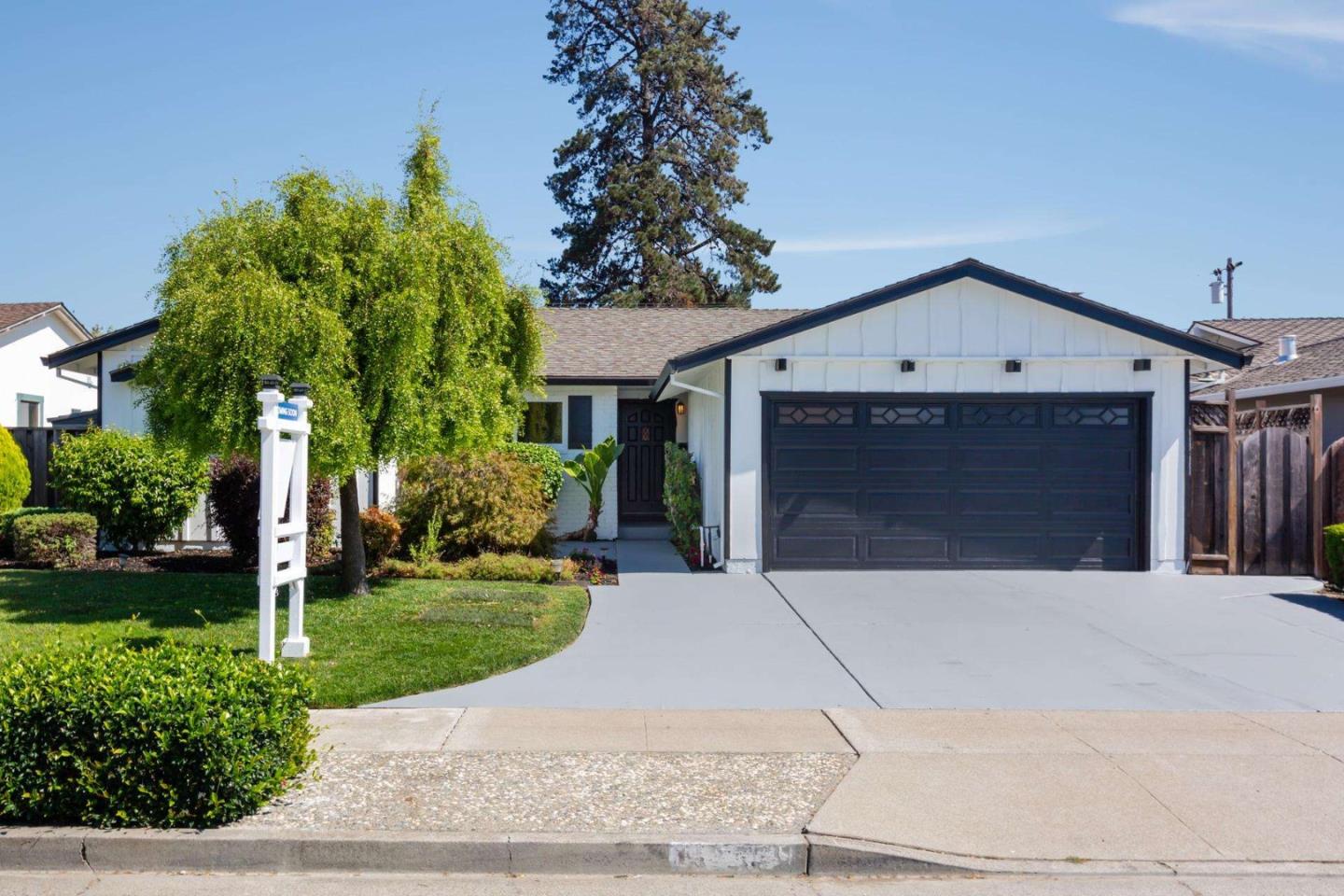 a front view of a house with a garden and trees