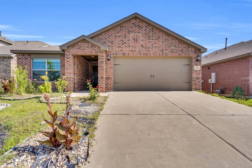 a view of a house with potted plants and a table and chairs