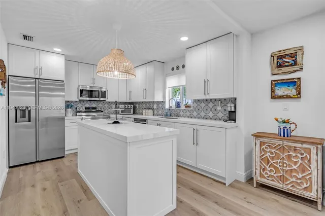 a kitchen with granite countertop a white stove top oven and refrigerator