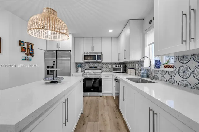 a kitchen with granite countertop a sink dishwasher a stove and a refrigerator