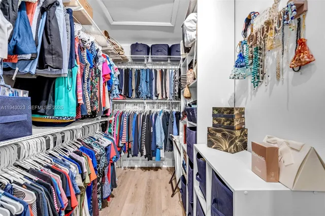 a view of walk in closet with clothes and shoes