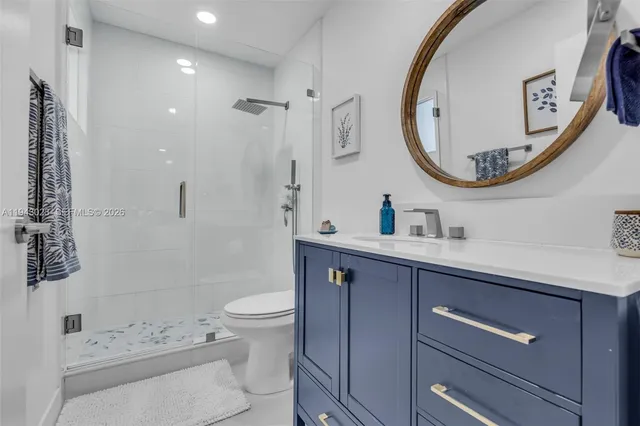 a bathroom with a toilet a sink a mirror and a shower