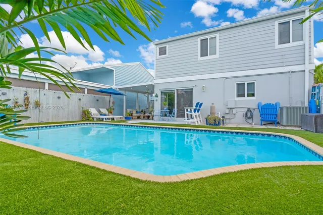 a view of a house with pool and a yard