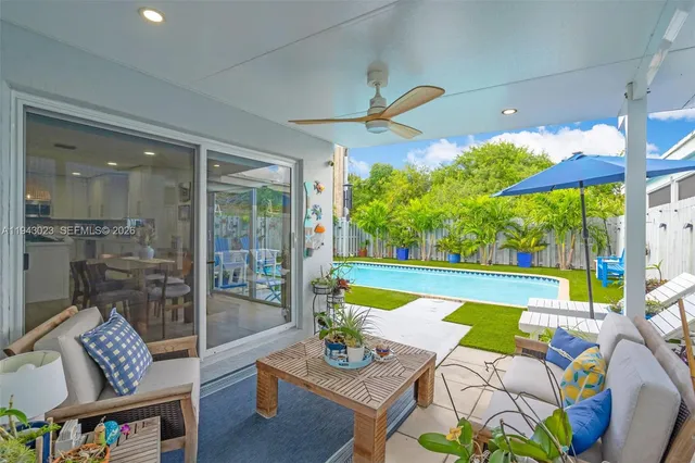 a living room with patio furniture and a large window