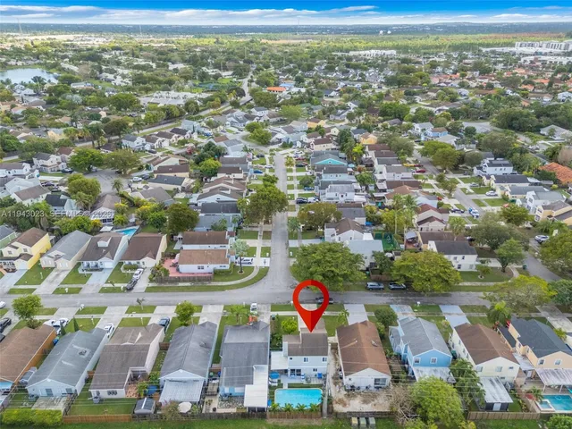 an aerial view of residential houses with outdoor space and parking