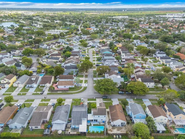 an aerial view of residential houses with outdoor space and parking