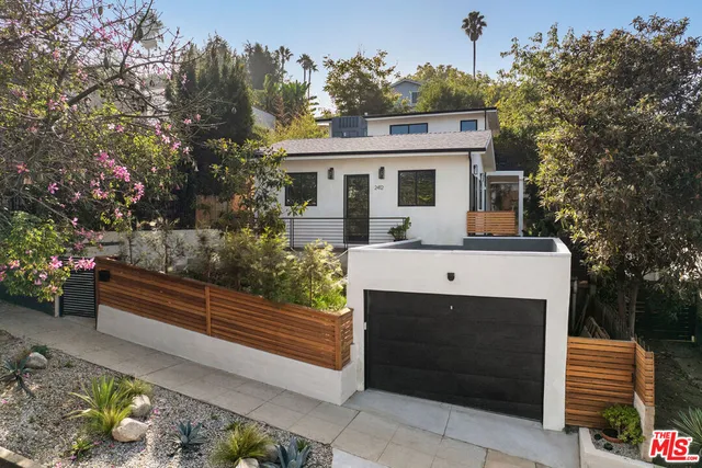 a front view of a house with a garden