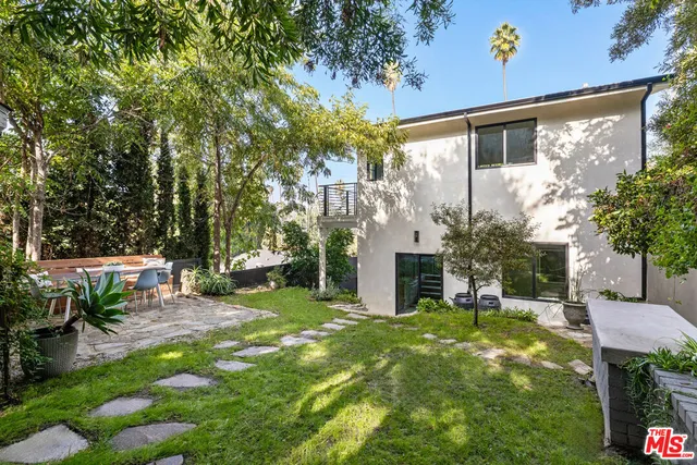 a view of a chair and table in backyard of the house