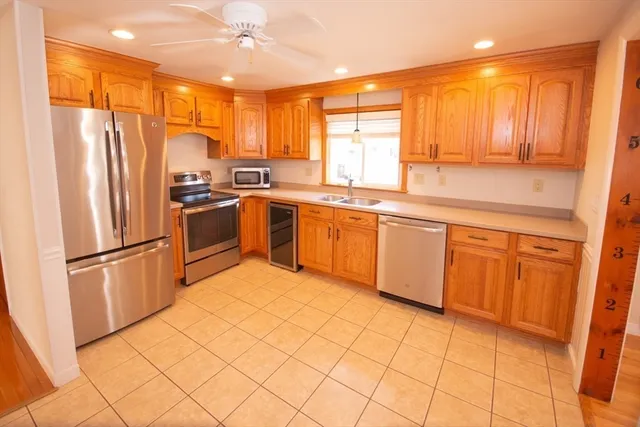 a kitchen with stainless steel appliances granite countertop a refrigerator a sink a stove a washer dryer and a dining table