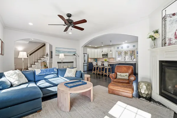a living room with furniture a fireplace and a ceiling fan