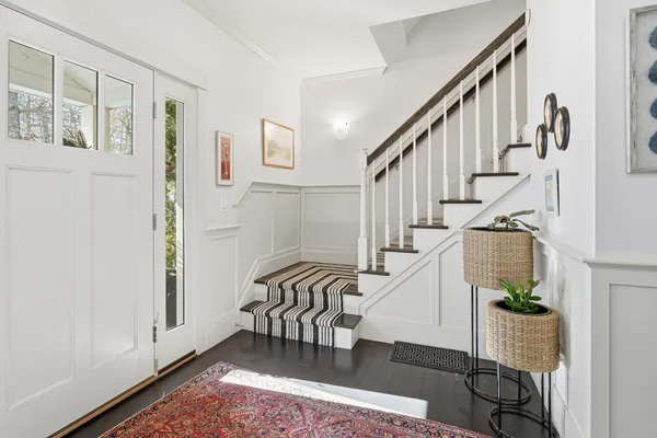 a view of entryway and hall with wooden floor