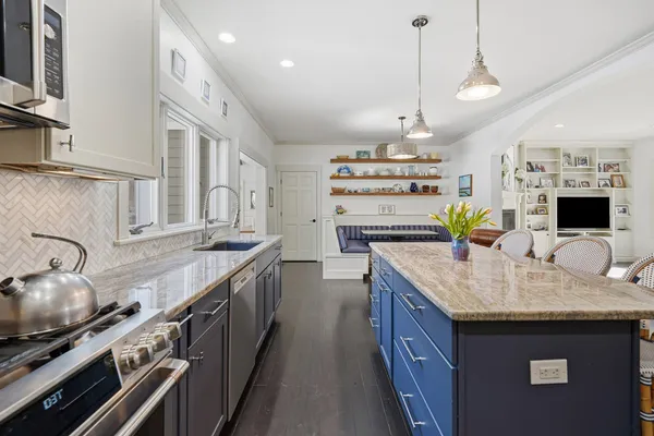 a kitchen with stainless steel appliances granite countertop a sink a stove and a wooden floors