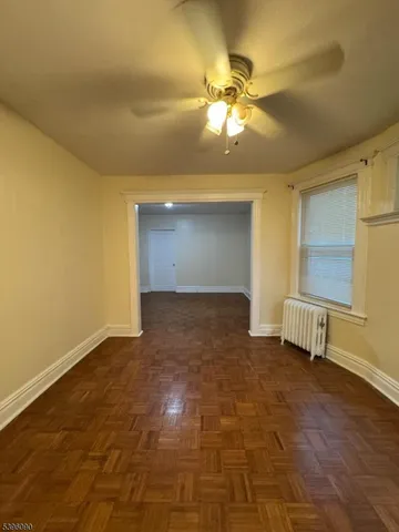 a view of an empty room with a chandelier fan