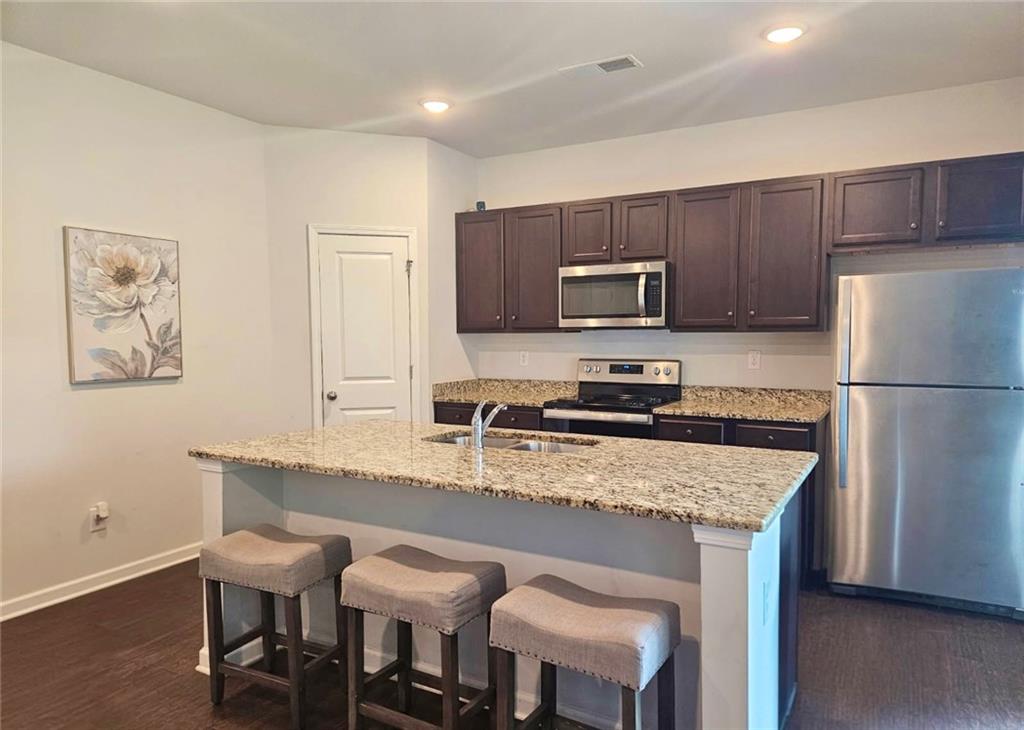 110 Halibut Circle Covington, GA 30016 - Photo 6 of 15 a kitchen with a refrigerator a stove a sink and a refrigerator