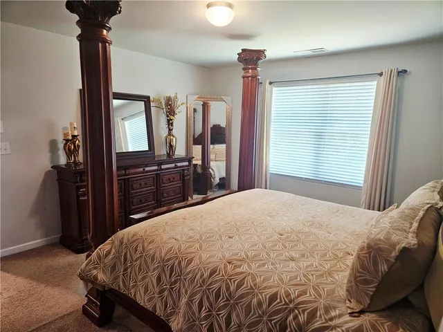 a bed sitting in a bedroom next to a window