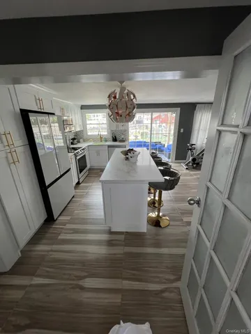 a room with lots of white furniture and wooden floor