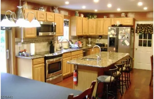 a kitchen with stainless steel appliances granite countertop a sink a stove and a refrigerator