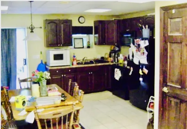 a kitchen with stainless steel appliances kitchen island granite countertop a refrigerator a microwave oven a sink and dishwasher