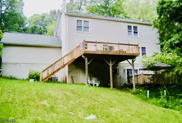 a front view of house with yard and trees in the background