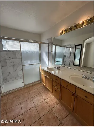 a bathroom with a granite countertop sink a mirror and a shower