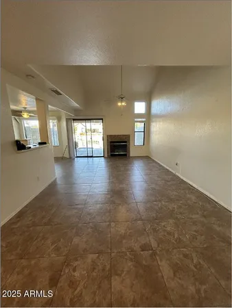 an empty room with fireplace and windows