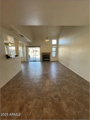an empty room with fireplace and windows