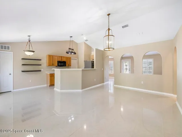 a view of a kitchen with wooden floor and windows