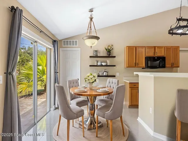 a dining room with furniture a chandelier and wooden floor