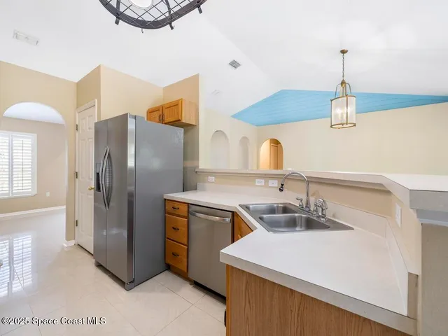a kitchen with kitchen island a sink a counter space and stainless steel appliances