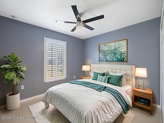 a bedroom with a large bed and a potted plant