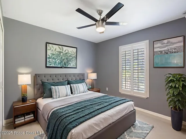 a bedroom with a large bed and a potted plant