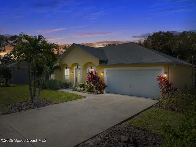 a view of a house with a yard and a street