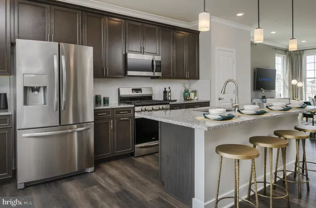 a kitchen with kitchen island granite countertop a sink stove and refrigerator