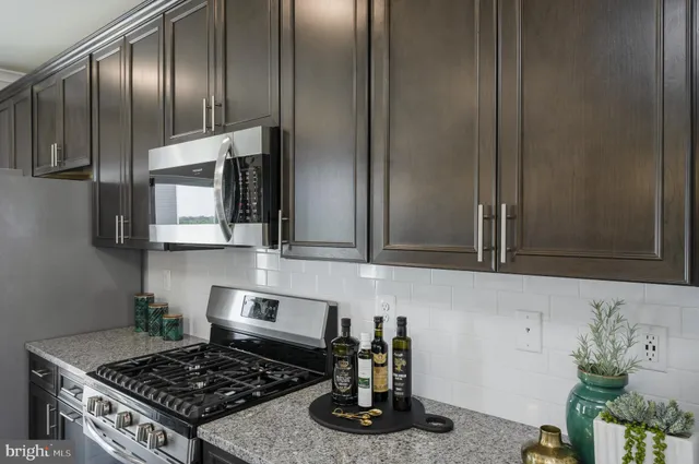 a kitchen with granite countertop a stove and cabinets