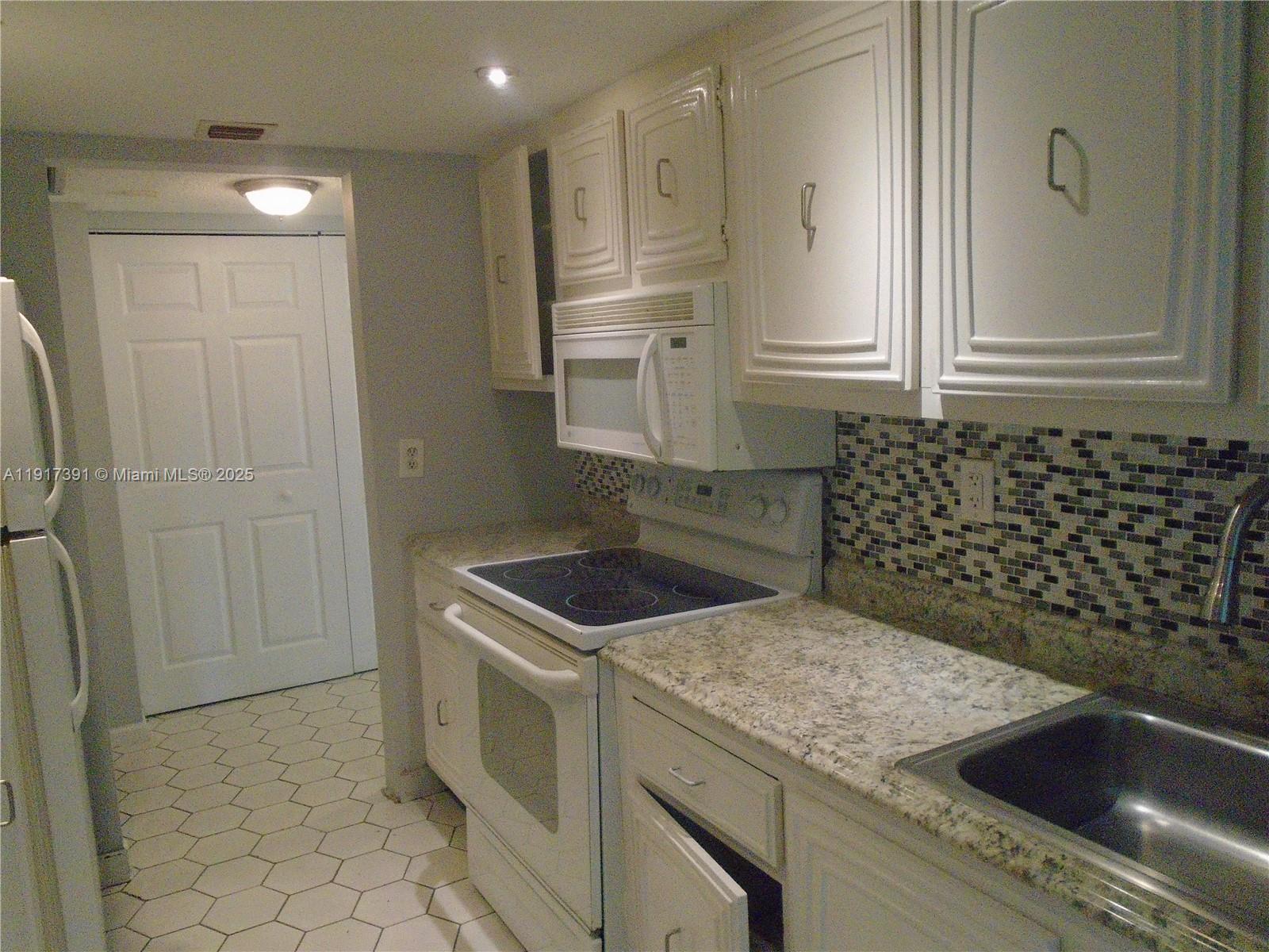 7051 Environ Boulevard, Unit 136 Lauderhill, FL 33319 - Photo 22 of 23 a kitchen that has a sink and a stove