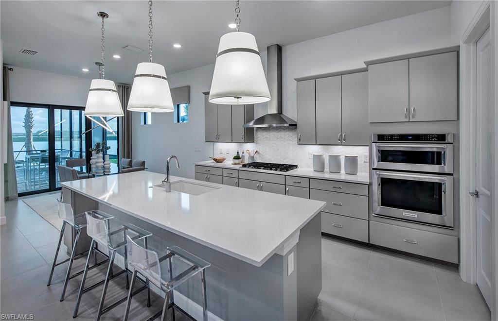 20155 Napa Loop Estero, FL 33928 - Photo 12 of 35 a kitchen with kitchen island cabinets and chandelier