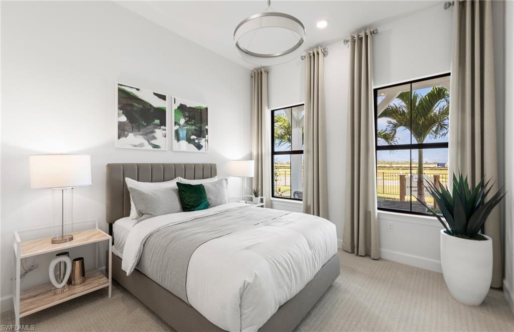 20155 Napa Loop Estero, FL 33928 - Photo 16 of 35 a bedroom with a large bed and a chandelier
