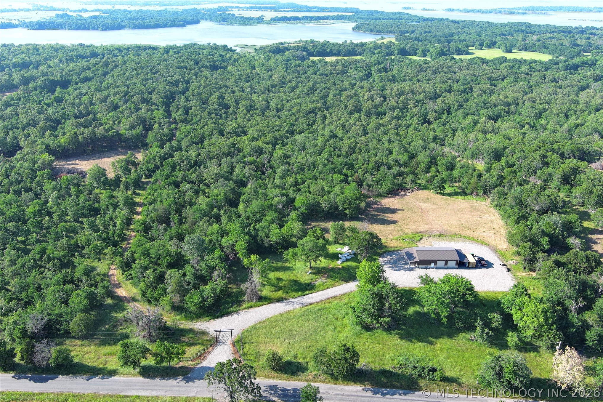 20862 East 1160th Road Keota, OK 74941 - Photo 9 of 47 Expansive wooded property featuring a single-story structure, gravel driveway, and cleared land