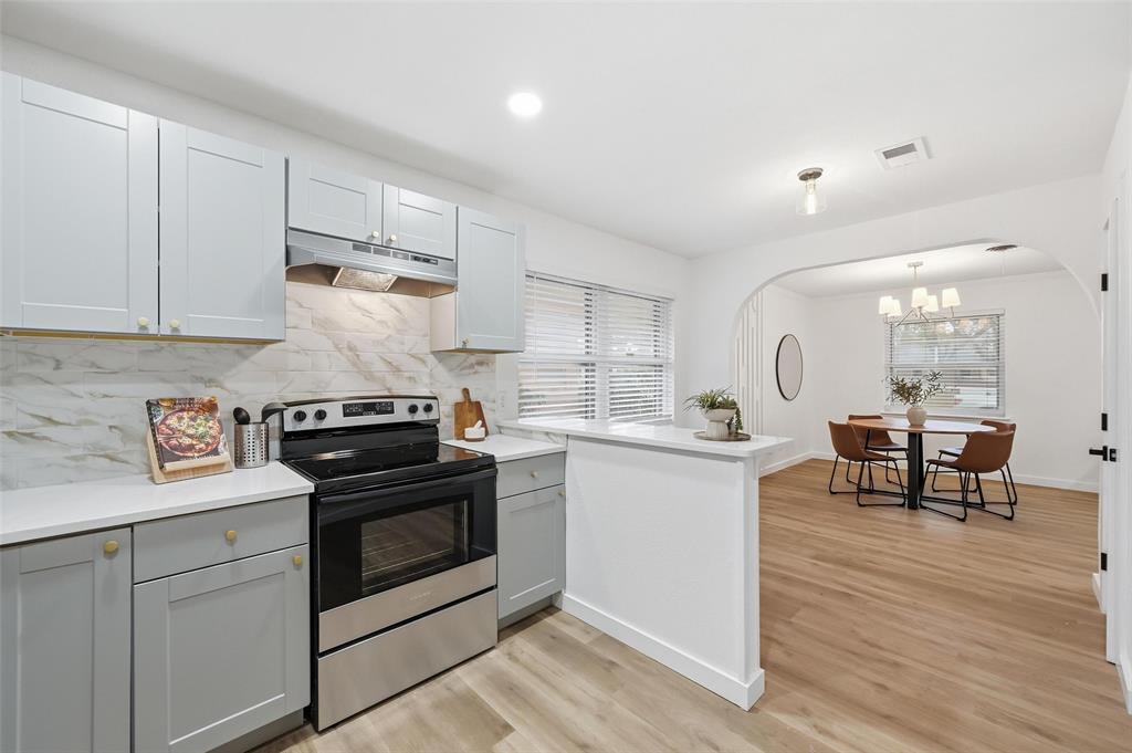816 Green Cove Lane Dallas, TX 75232 - Photo 12 of 24 a kitchen with a stove and white cabinets