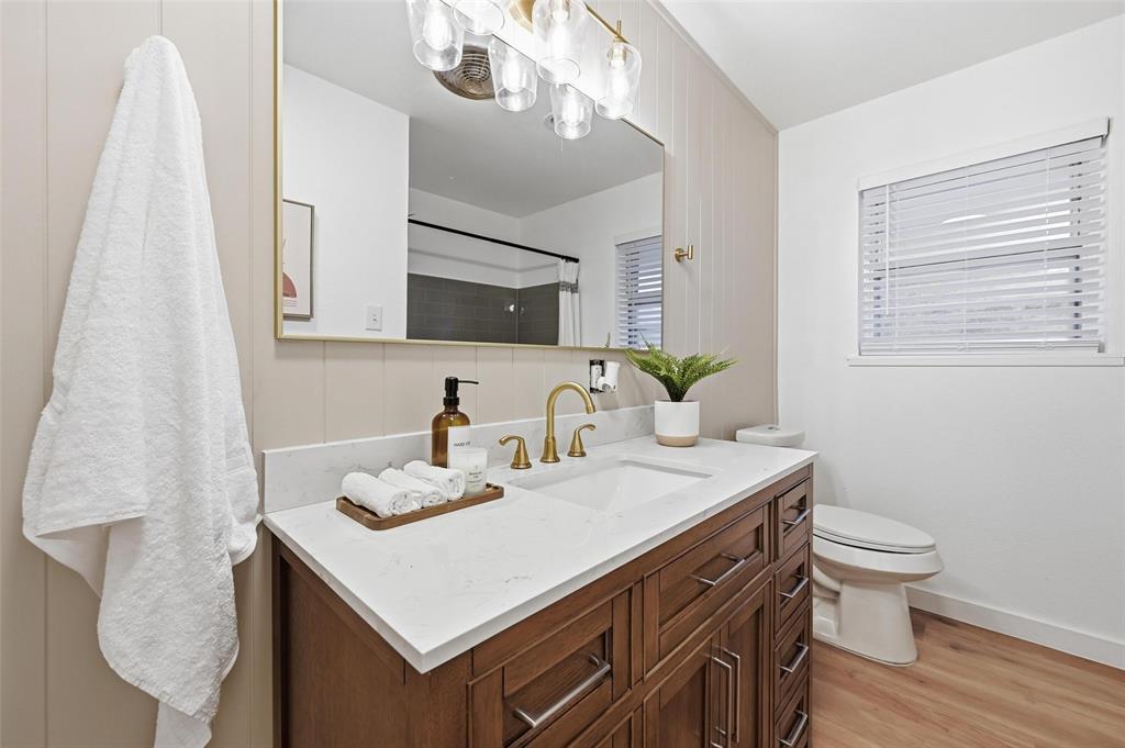 816 Green Cove Lane Dallas, TX 75232 - Photo 15 of 24 a bathroom with a sink a toilet and a mirror
