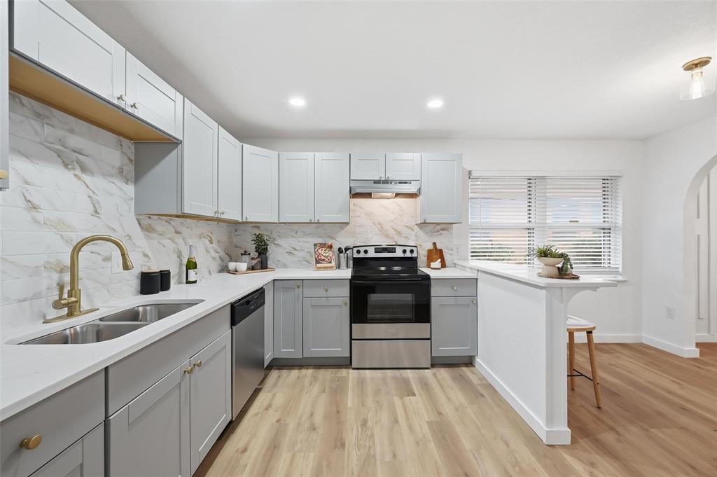 816 Green Cove Lane Dallas, TX 75232 - Photo 3 of 24 a kitchen with stainless steel appliances granite countertop a sink and cabinets