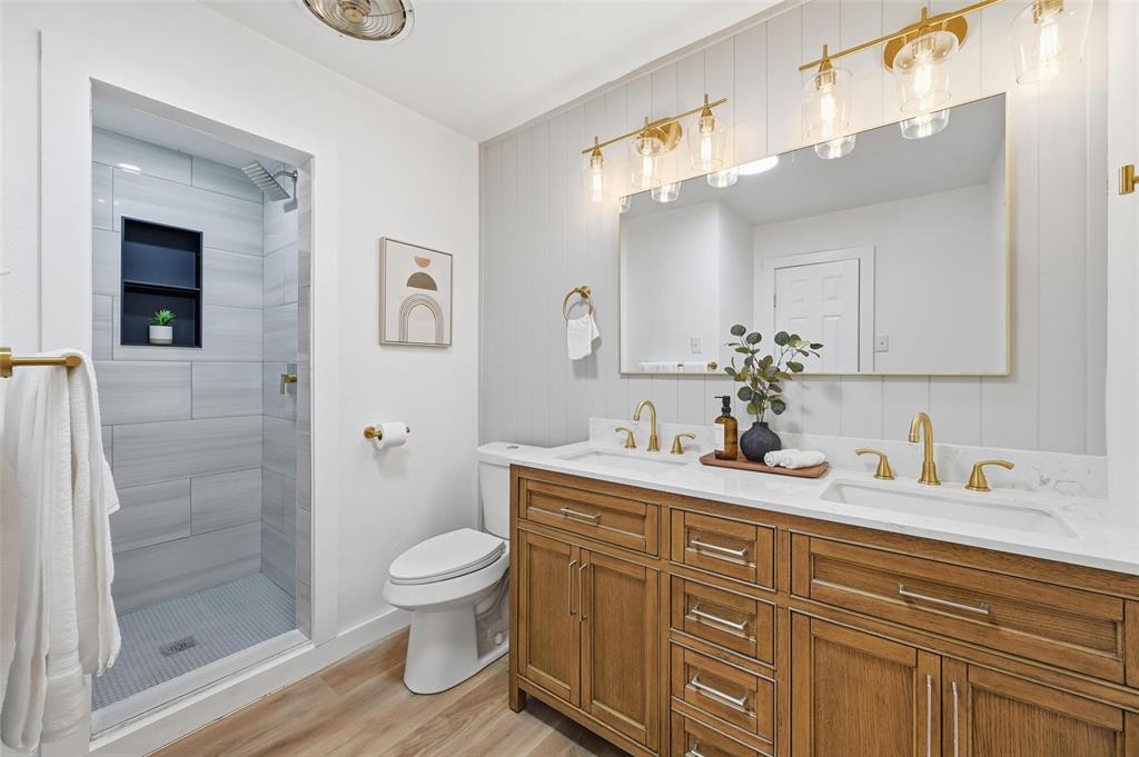 816 Green Cove Lane Dallas, TX 75232 - Photo 4 of 24 a bathroom with a granite countertop sink a toilet and a mirror