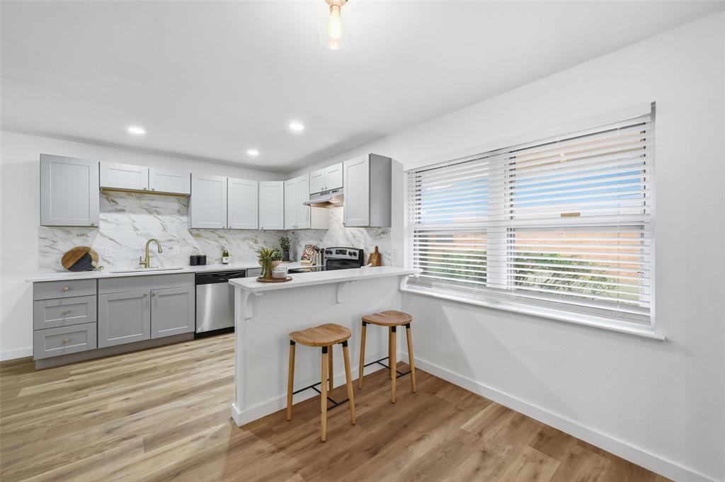 816 Green Cove Lane Dallas, TX 75232 - Photo 10 of 24 a kitchen with a window a sink and a refrigerator