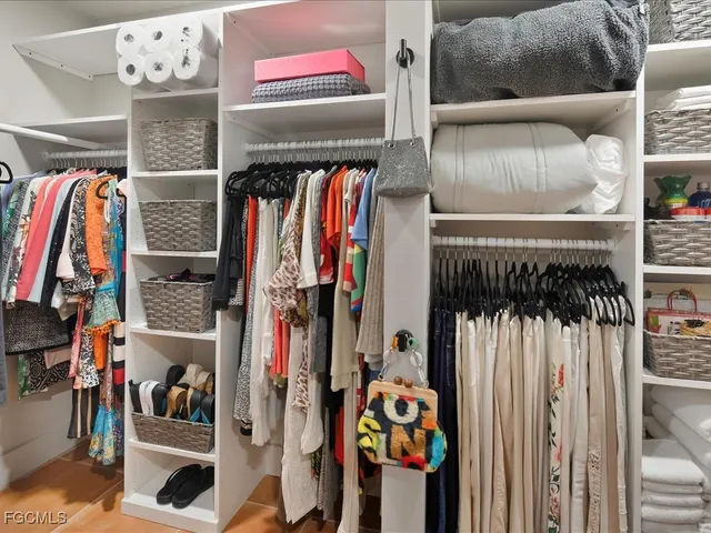 a view of walk in closet with clothes and shoes