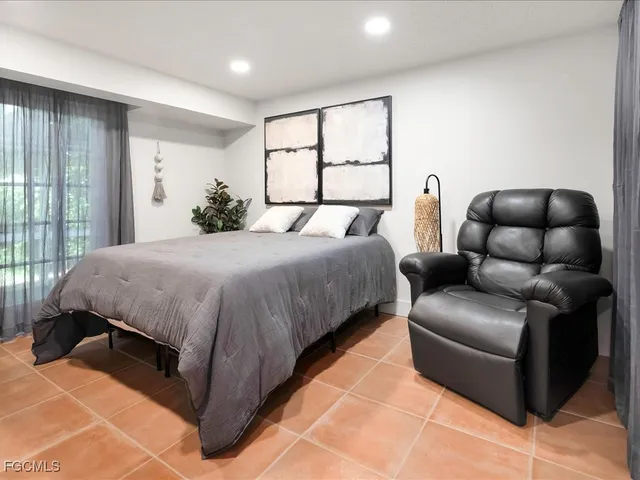 a bedroom with a bed couch and window